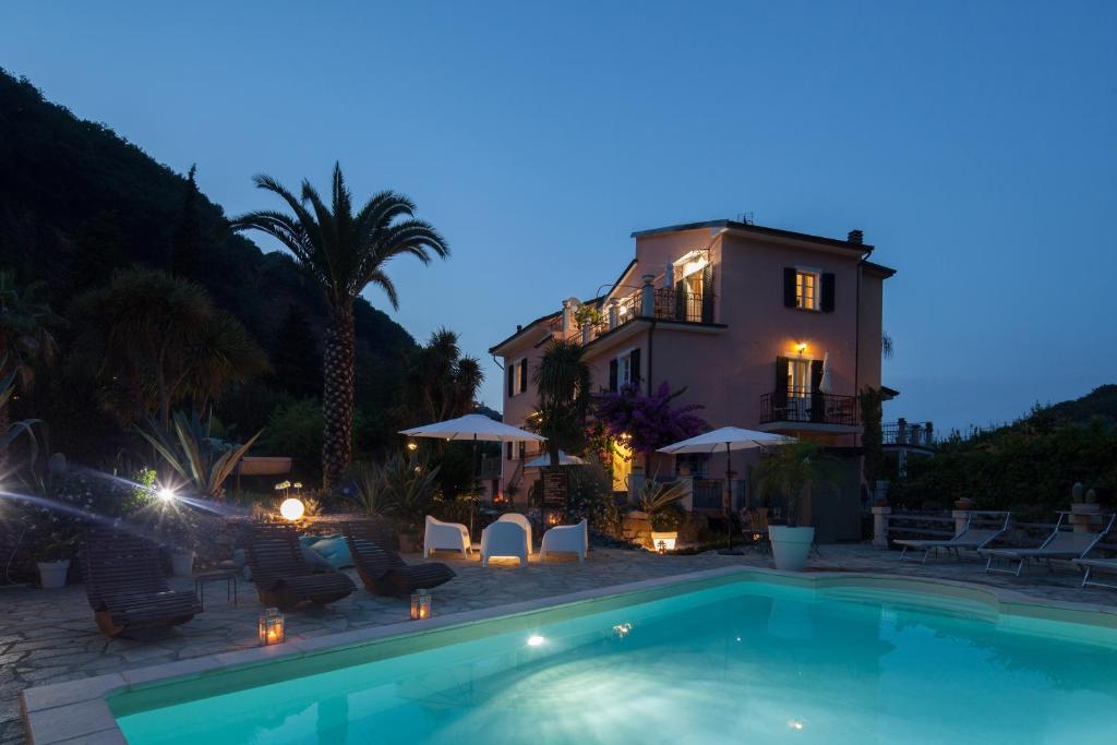a villa with a swimming pool in front of a house at La Musa in Lerici