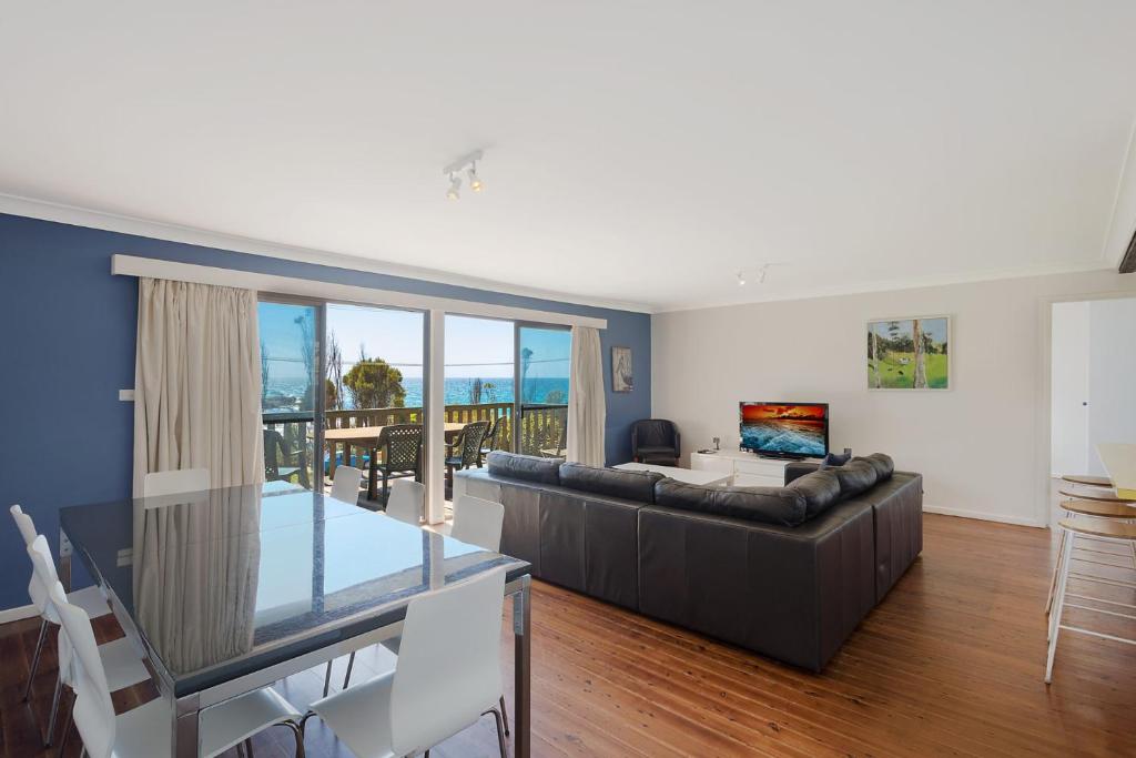 a living room with a couch and a table at 74 Ocean Parade in Dalmeny