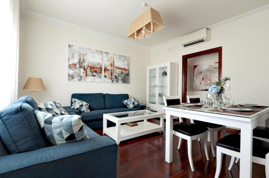 a living room with a blue couch and a table at Classbedroom Fira Business Apartment in Barcelona