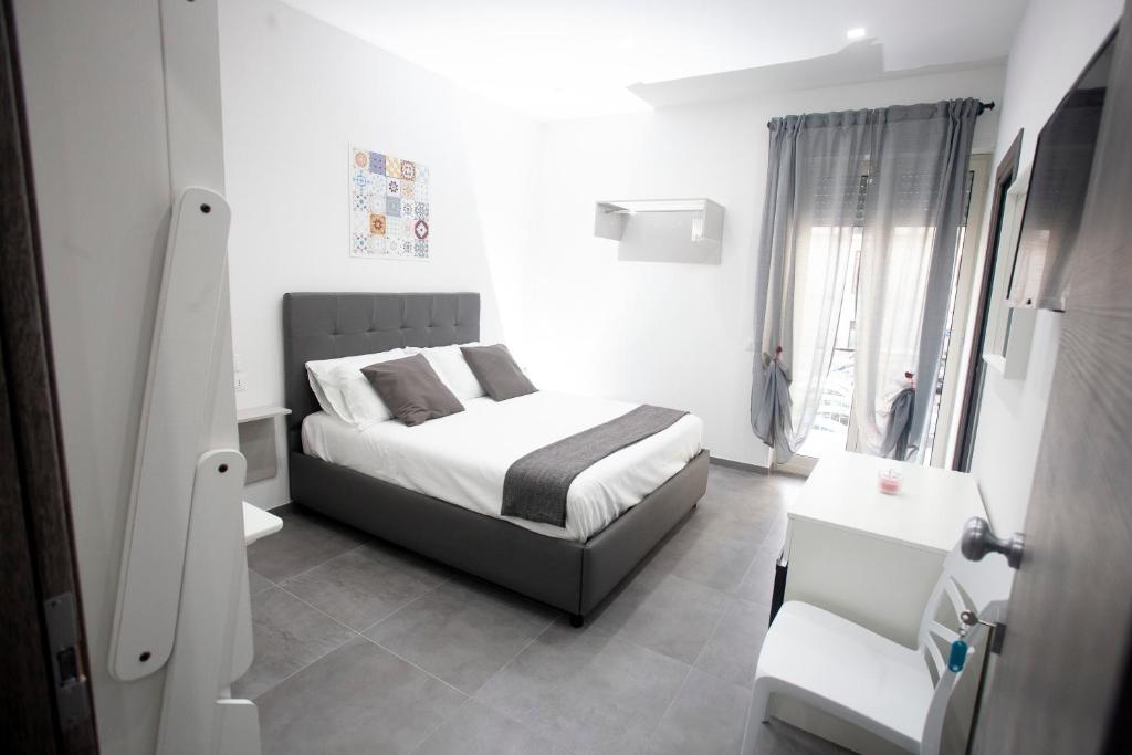 ein weißes Schlafzimmer mit einem Bett und einem Fenster in der Unterkunft Amazing Napoli in Neapel