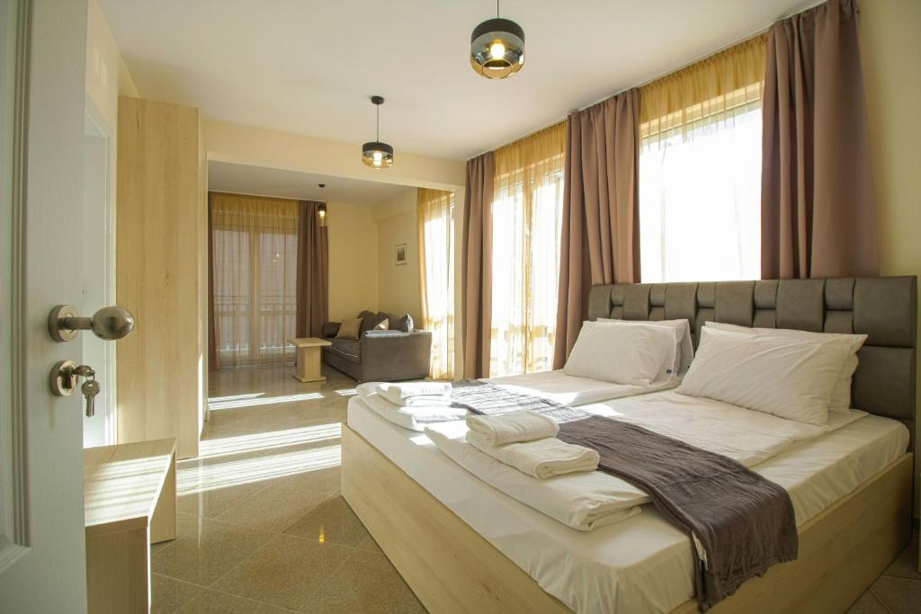 um quarto com uma cama grande e almofadas brancas em Mini Sofia em Sófia