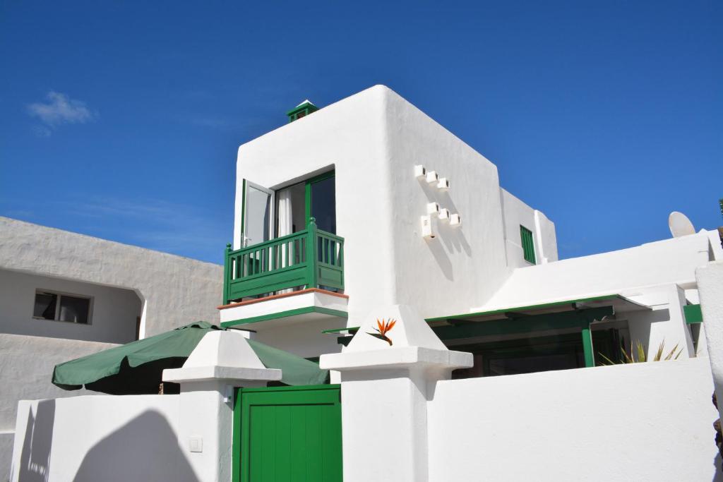 una casa blanca con una puerta verde y una valla en Ave Paraíso en Puerto del Carmen