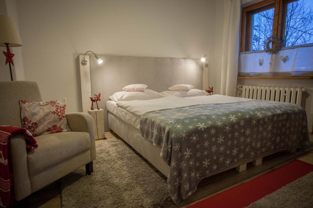 um quarto com uma cama grande e uma cadeira em Gościniec i Herbaciarnia Pod Złotą Łyżwą em Białka Tatrzanska
