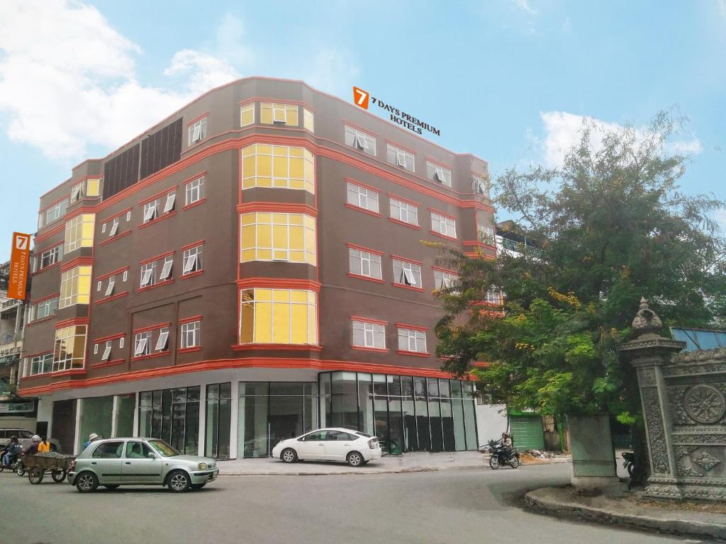 a red building with cars parked in front of it at 7 Days Premium Hotel Phnom Penh in Phnom Penh