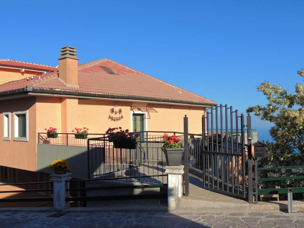 een huis met een hek en bloemen erop bij B&B Angela in Monte SantʼAngelo