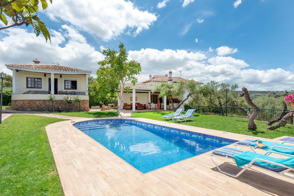 a backyard with a swimming pool and a house at Villa Maria in Ronda