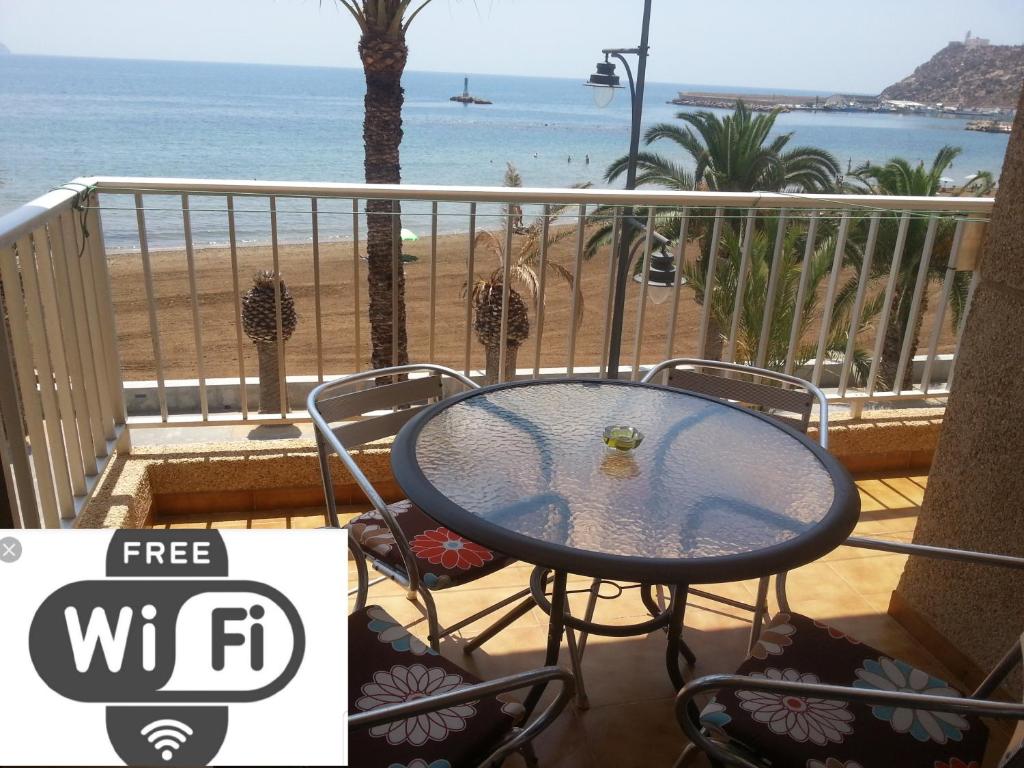 una mesa en un balcón con vistas a la playa en BAHIA MAZARRON apartamento en primera linea playa, en Puerto de Mazarrón