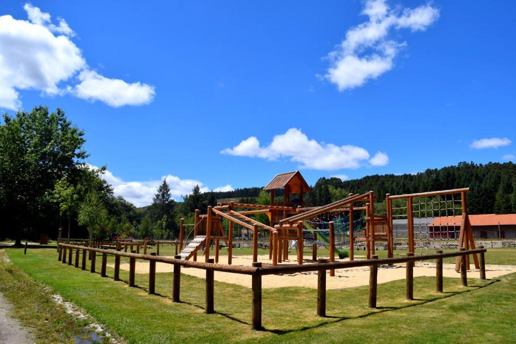 um parque com um parque infantil de madeira na relva em Boticas Parque Natur Houses em Boticas