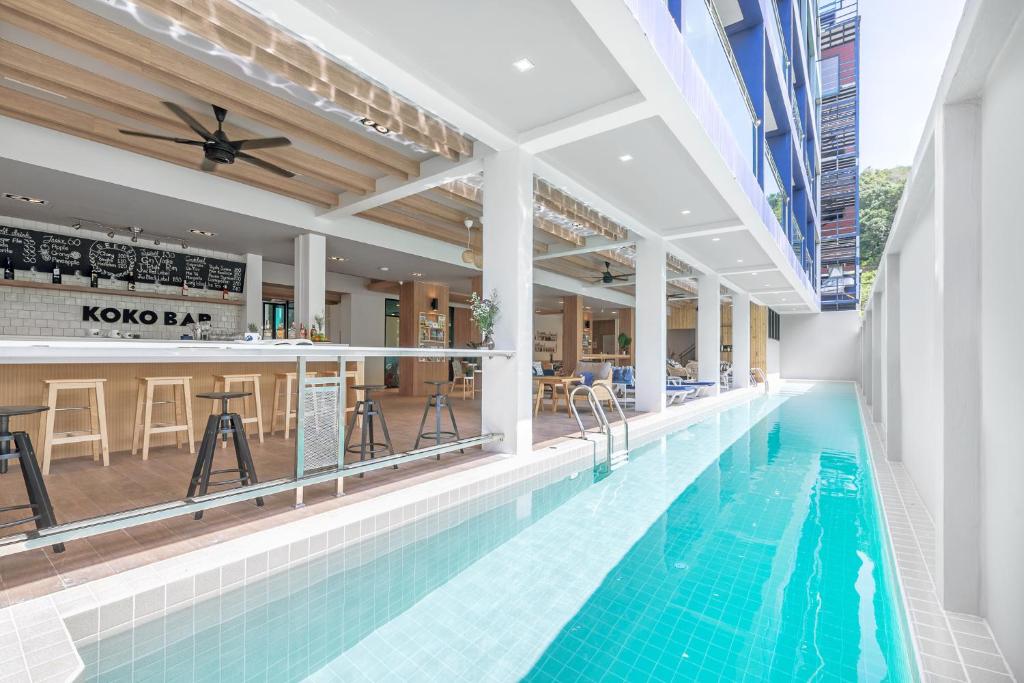 an indoor pool with a bar and a restaurant at Kokotel Krabi Oasis in Ao Nang Beach