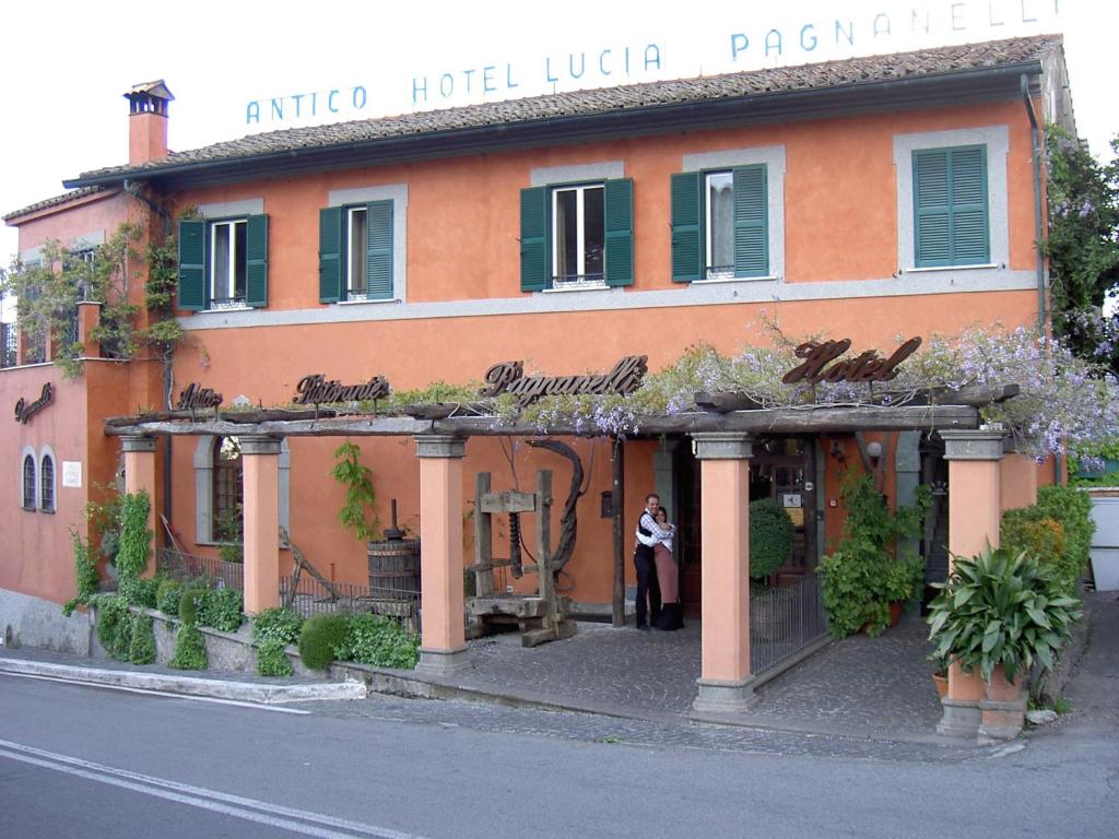 Una donna in piedi di fronte a un palazzo di Albergo Lucia Pagnanelli a Castel Gandolfo