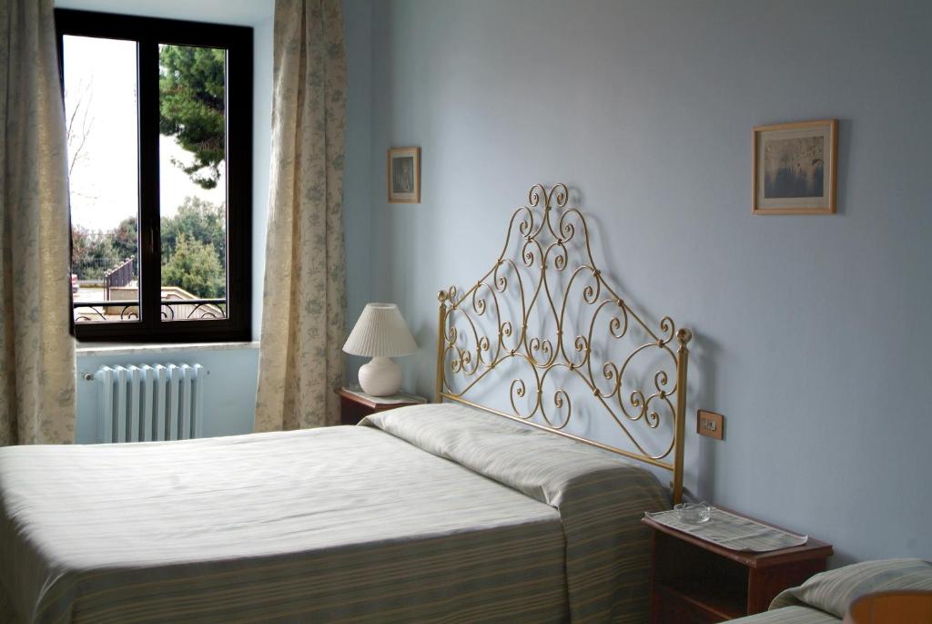 una camera da letto con due letti e una finestra di Albergo Lucia Pagnanelli a Castel Gandolfo