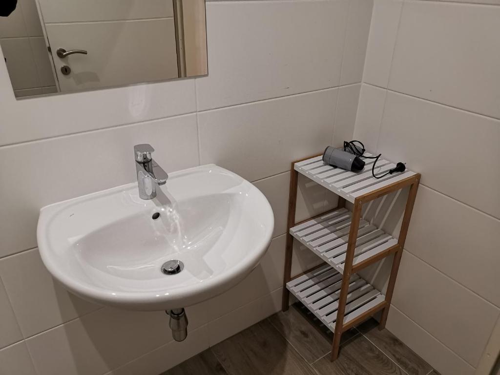 a bathroom with a sink and a mirror and a shelf at Ferienwohnung Diefenbachgasse in Vienna