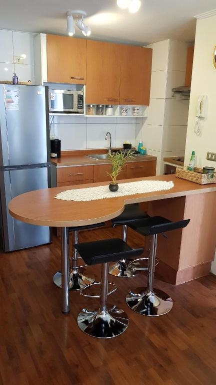 cocina con mesa de madera y 2 taburetes en Santiago Centro - Tarapaca, en Santiago