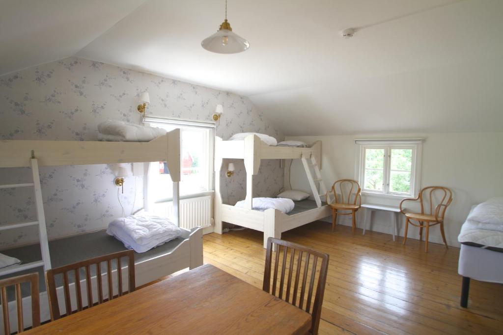 a room with two bunk beds and chairs at Tjärö Hotell & Vandrarhem in Trensum