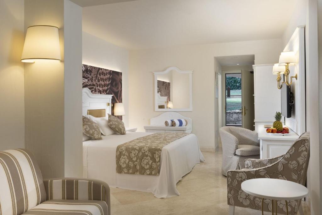 a hotel room with a bed and a sitting area at Hotel Abi d'Oru in Porto Rotondo