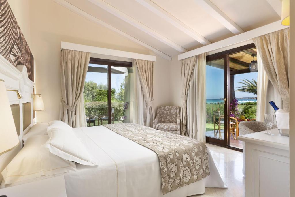 a hotel room with two beds and a window at Hotel Abi d'Oru in Porto Rotondo