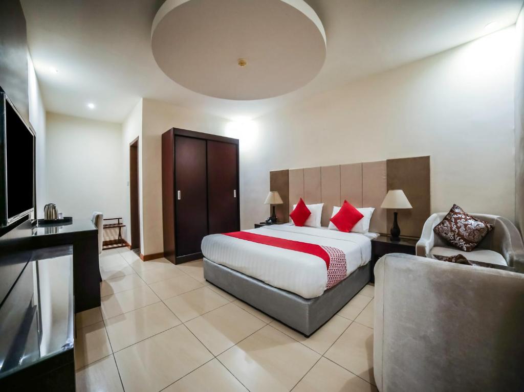 Habitación de hotel con cama, sofá y TV en Night Inn Hotel en Al Khobar