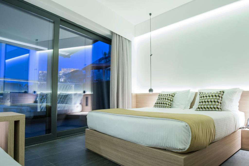 een slaapkamer met een bed en een groot raam bij Athens Lodge by Athens Prime Hotels in Athene