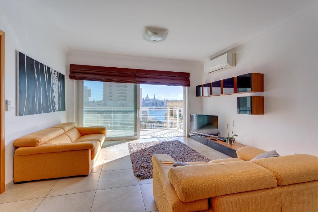 a living room with two couches and a large window at Apartment with Pool in Sliema