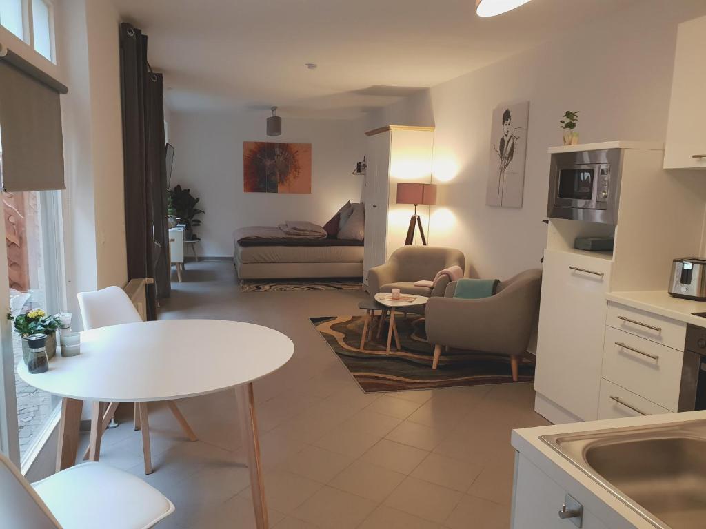 eine Küche und ein Wohnzimmer mit einem Tisch und einem Sofa in der Unterkunft Studioapartment G16 - in exklusiver Innenstadtlage in Potsdam