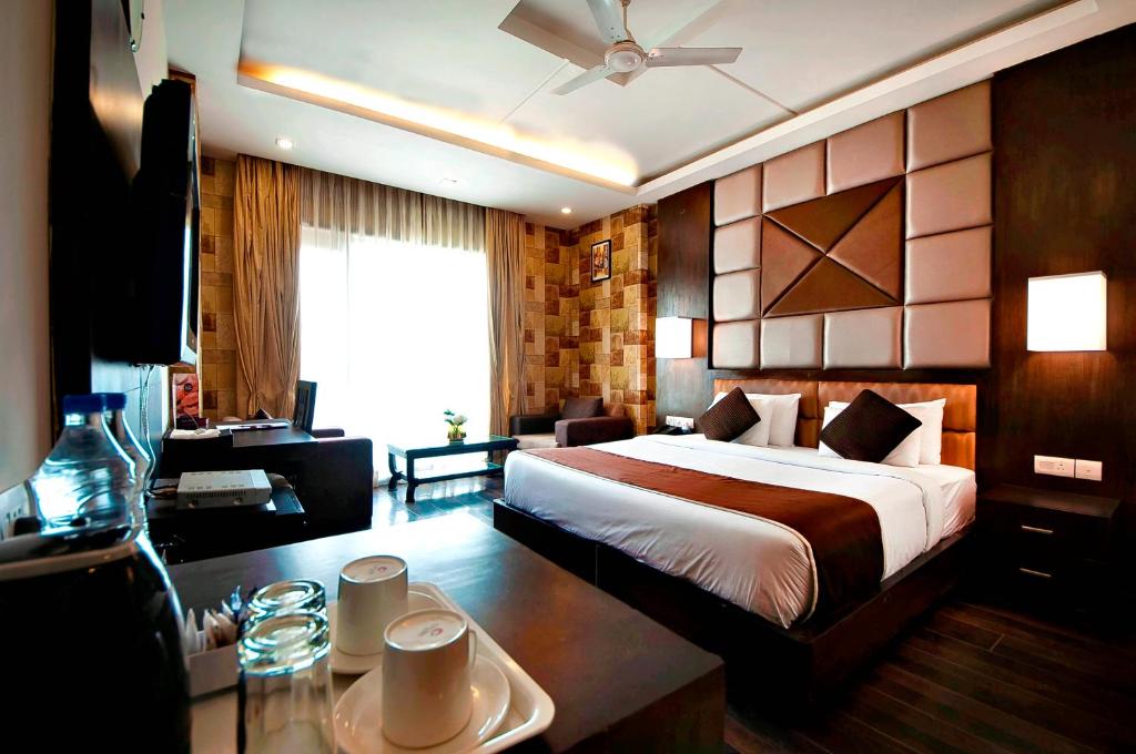 a hotel room with a bed and a desk at Hotel Golf View Suites-Golf Course Road Gurgaon in Gurgaon
