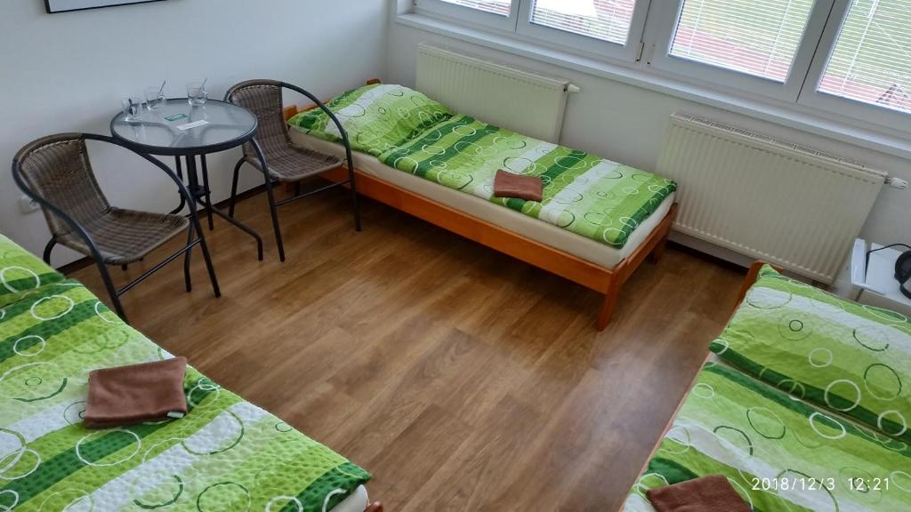 チェスキー・クルムロフにあるウビトヴァーニ ナ ハジェシティのベッド2台とテーブルが備わる客室です。