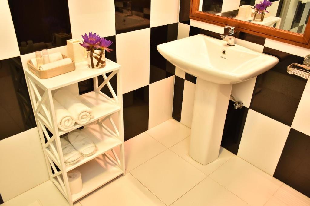 a bathroom with a sink and a mirror and a white sink at BeachMirissa Hotel in Mirissa