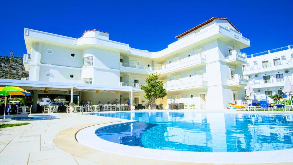 a hotel with a swimming pool in front of a building at Pela Sofia in Stalís