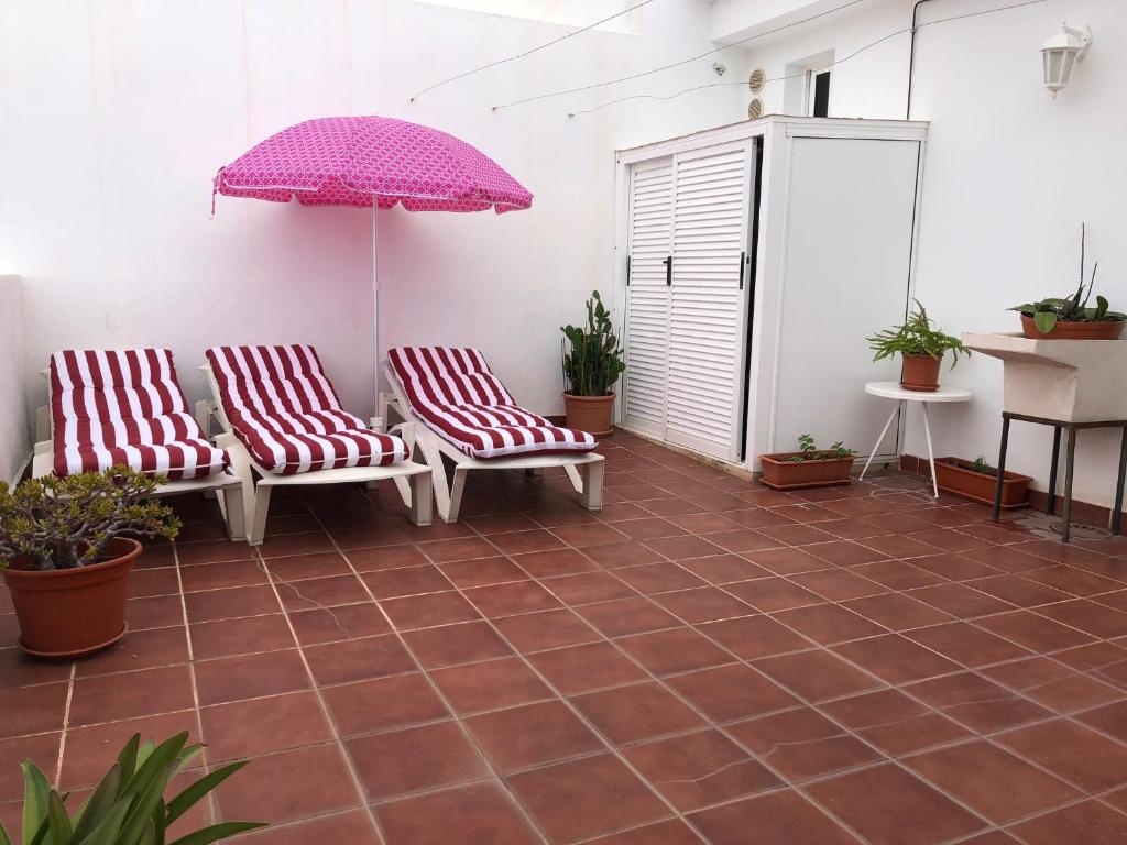 2 stoelen en een parasol op een patio bij ÁTICO ESTRELLA in Tejina de Isora