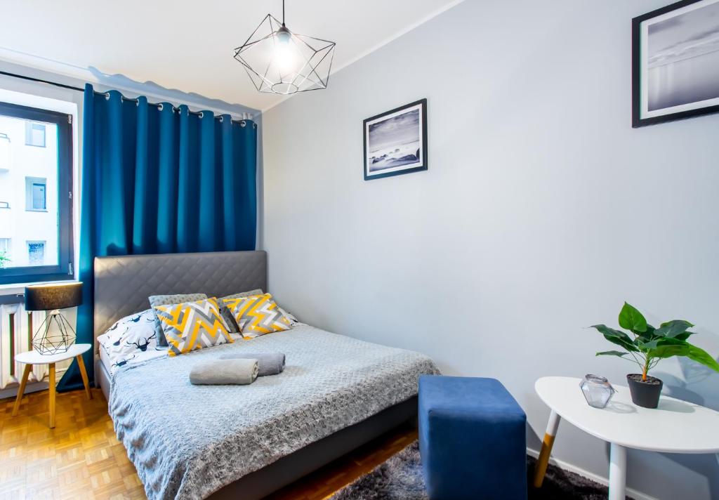 ワルシャワにあるClickTheFlat Wilcza Street Apart Roomsのベッドルーム(ベッド1台、青いカーテン付)