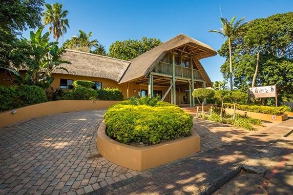 una casa con un gran edificio con techo en AmaZulu Lodge, en St Lucia
