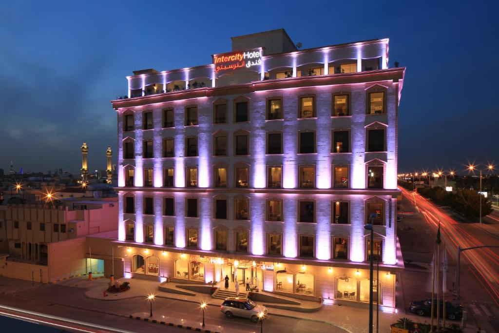 un edificio blanco con luces encendidas por la noche en IntercityHotel Riyadh Malaz en Riad