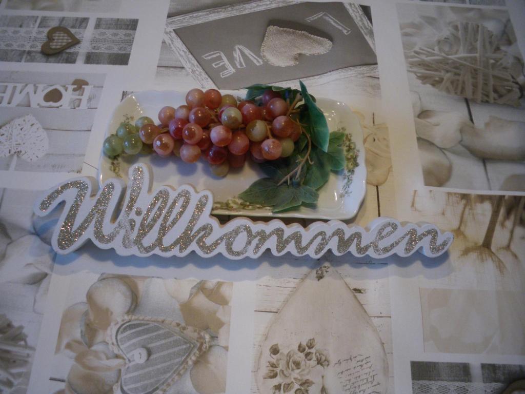 a sign with grapes on a plate on a table at Ferienwohnung am Jordan in Schneverdingen