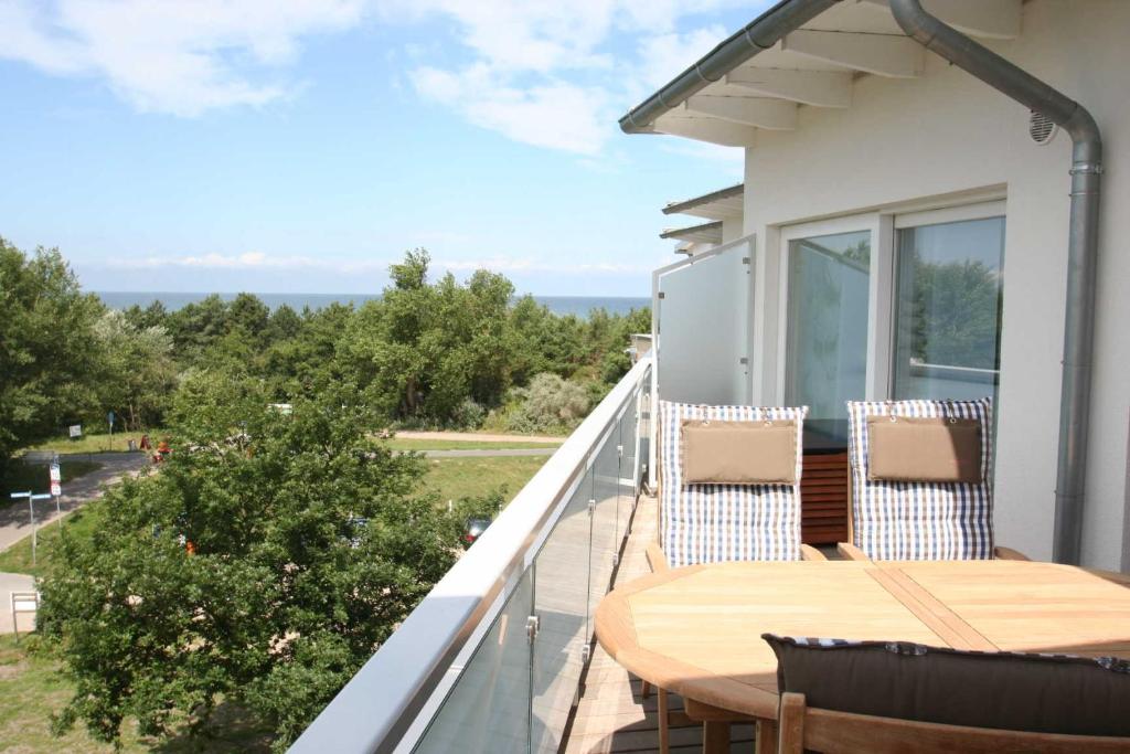 a balcony with a wooden table and chairs at OSTSEEPANORAMA Penth Nr 29 max 4 P in Dierhagen
