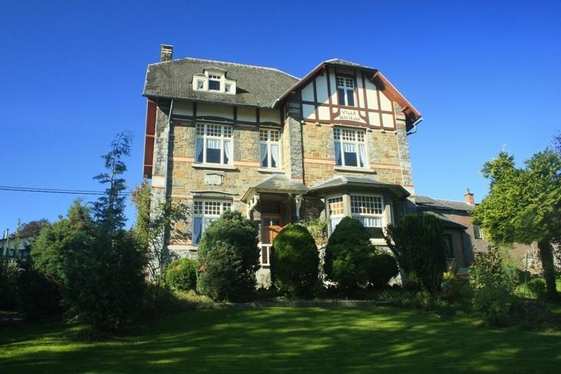 een groot bakstenen huis met een gazon ervoor bij Villa Belle Epoque in Hamoir