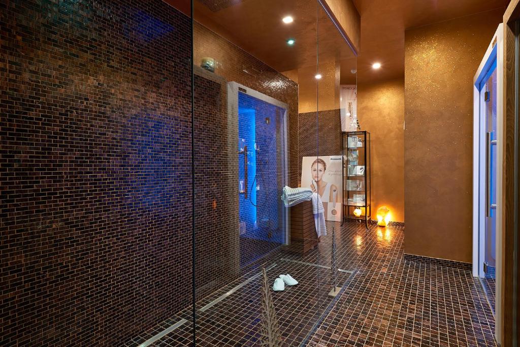 baño con ducha y puerta de cristal en Ricaroka Hotel, en Albenga