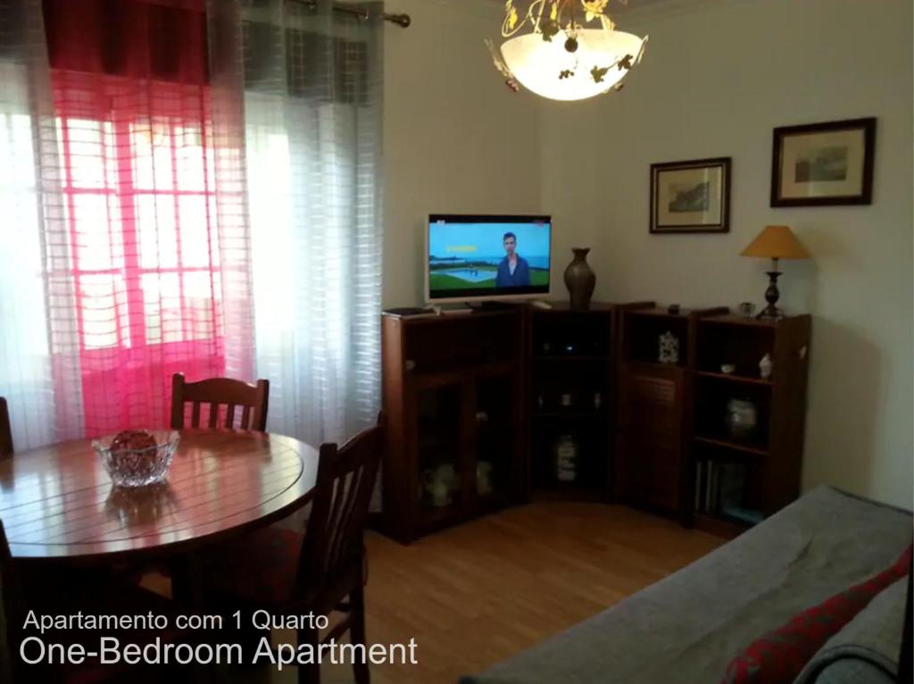 ein Wohnzimmer mit einem Tisch und einem TV in der Unterkunft Akicity Sintra Moss in Sintra