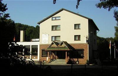 ein großes weißes Gebäude mit einer Treppe davor in der Unterkunft Hotel Talburg in Heiligenhaus