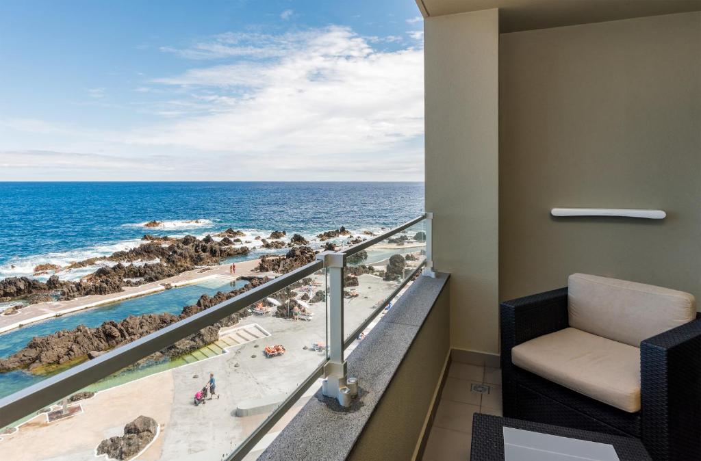 a room with a balcony with a view of the ocean at Aqua Natura Madeira in Porto Moniz