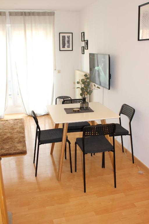 a table and chairs in a living room with a television at Ferienwohnung Mila am Bodensee nähe Messe in Friedrichshafen