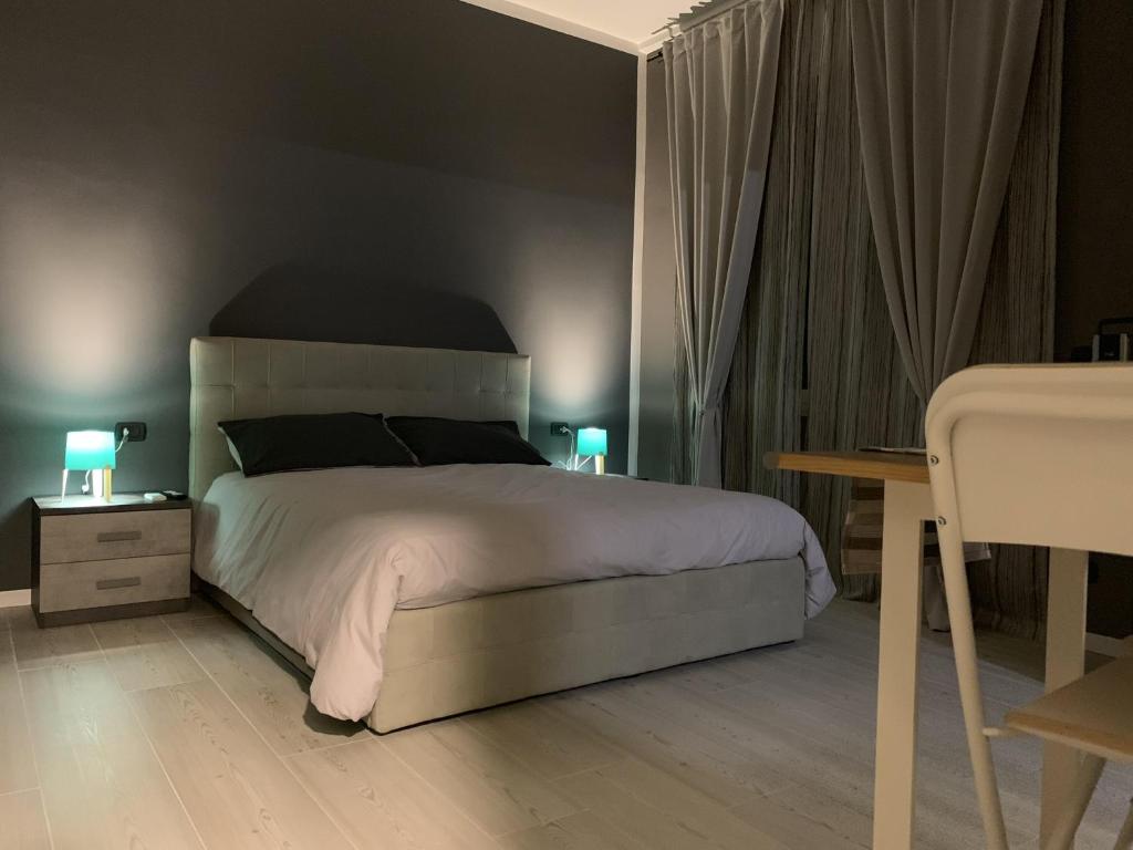 a bedroom with a large white bed with two lamps at Divi Bed & Breakfast in Bari