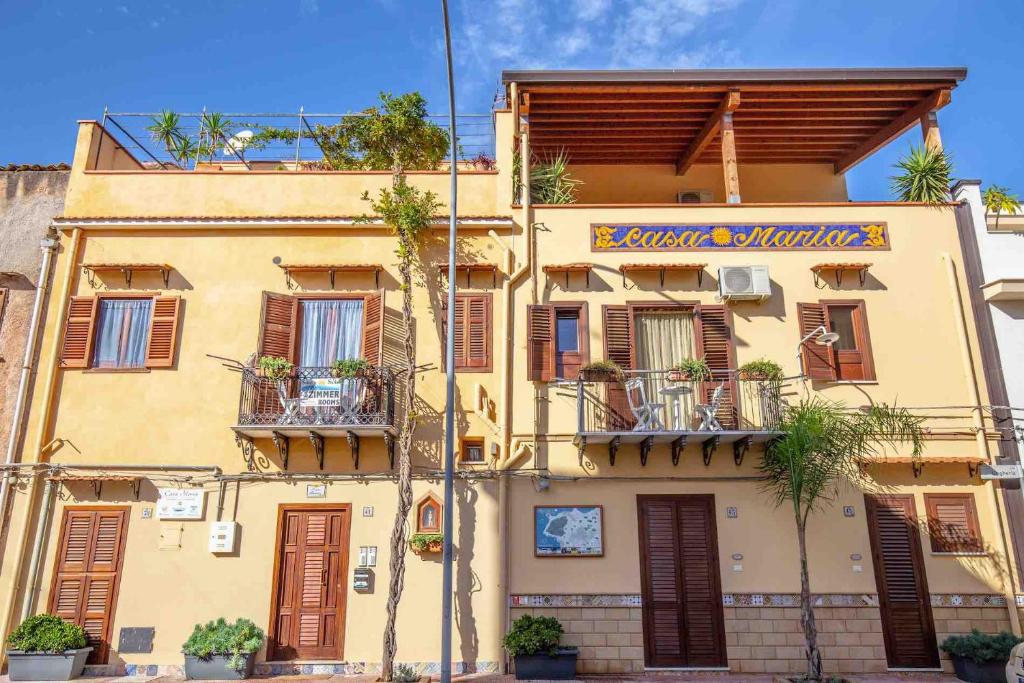 ein gelbes Gebäude mit einem Schild darauf in der Unterkunft Solemar Sicilia - Casa Maria in Santa Flavia