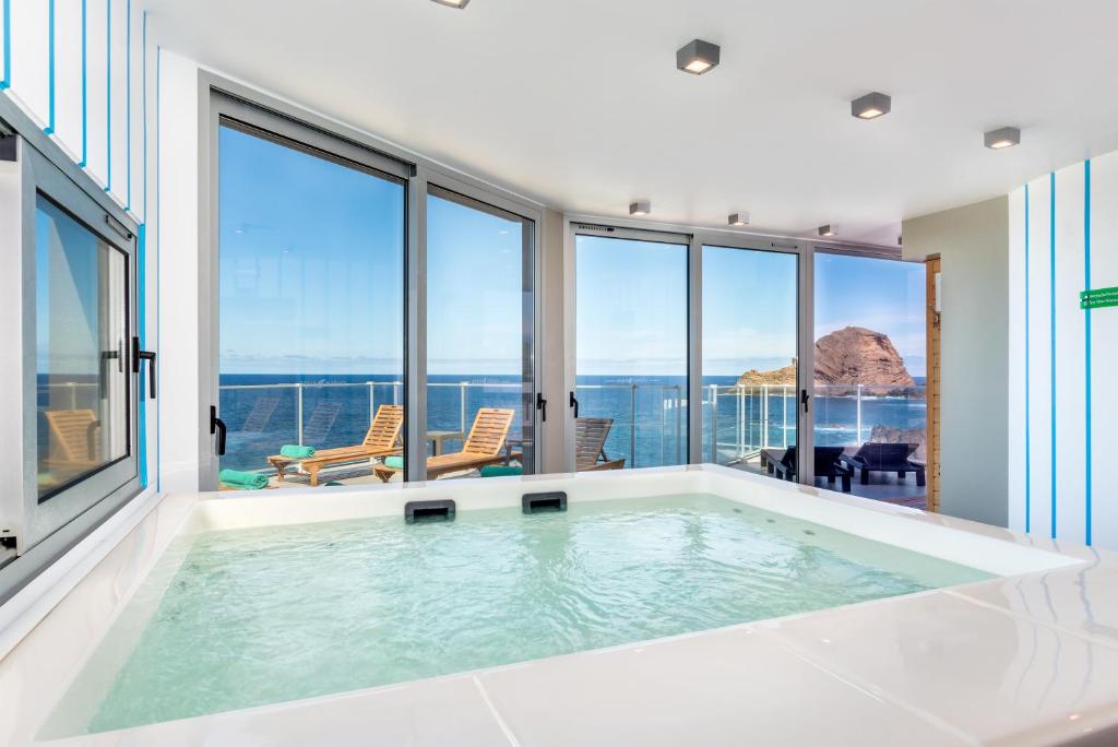 a large swimming pool with a view of the ocean at Aqua Natura Madeira in Porto Moniz