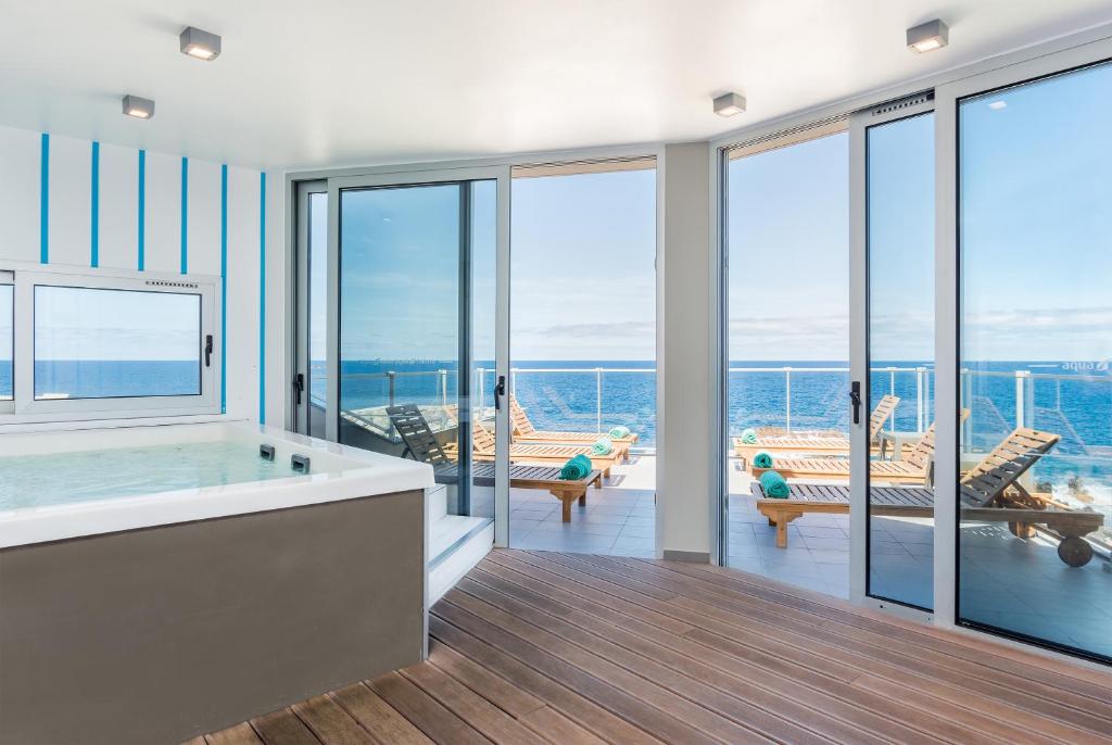 a large bathroom with a view of the ocean at Aqua Natura Madeira in Porto Moniz