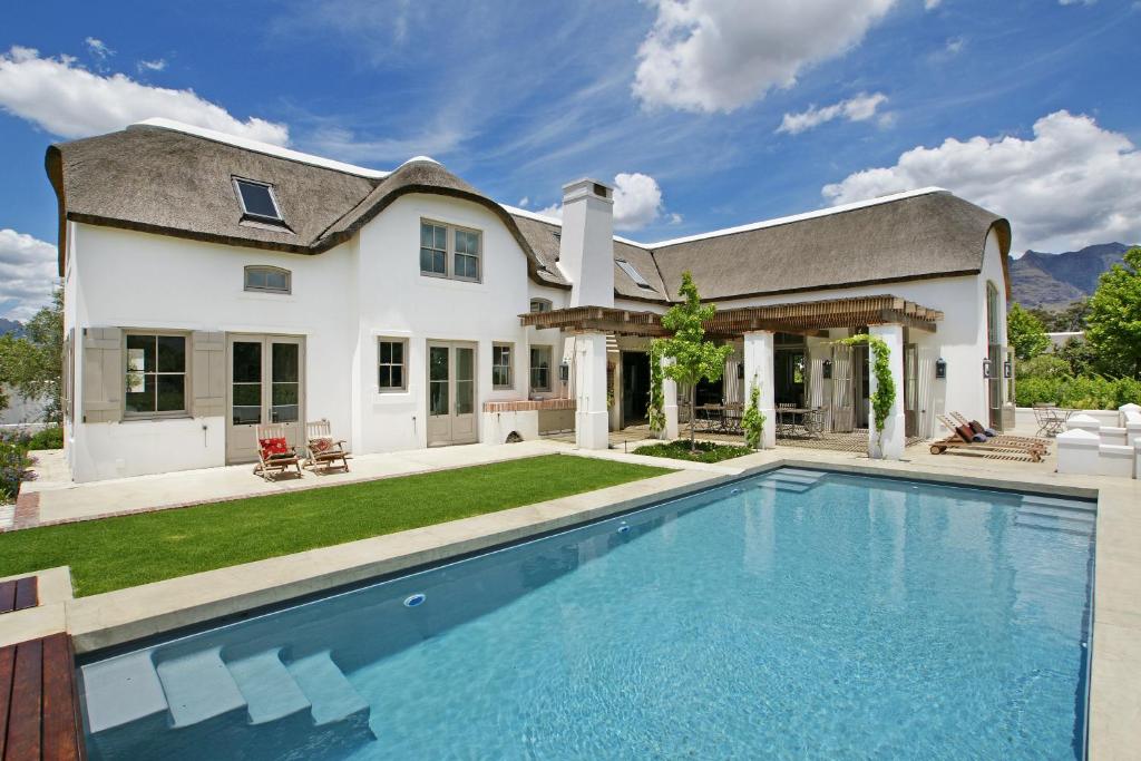 フランシュホークにあるVilla Simondiumの家の前にスイミングプールがある家