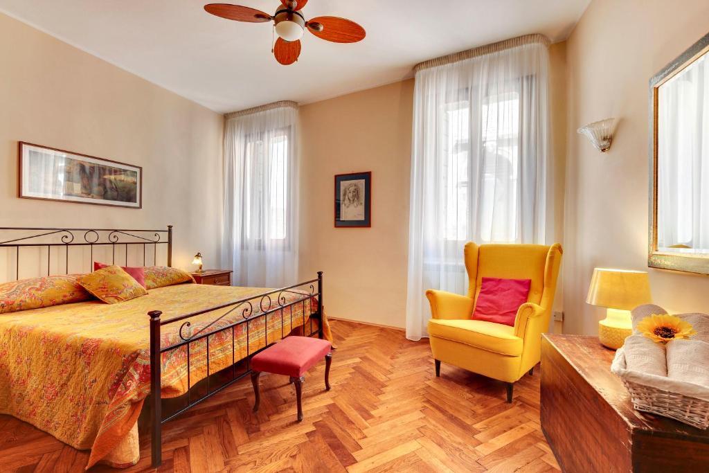 sypialnia z łóżkiem i żółtym krzesłem w obiekcie CasaMisa Formosa 5193 w Wenecji