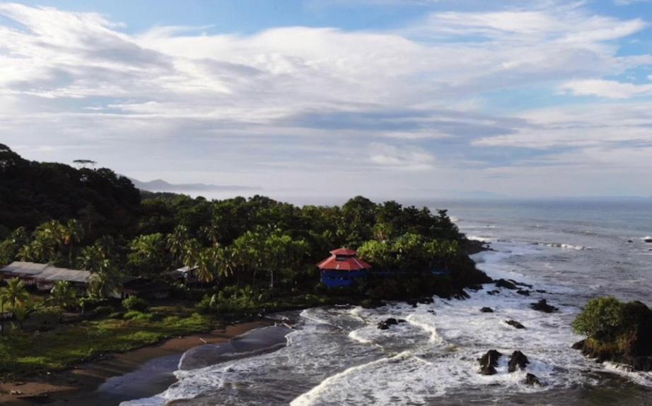 a view of the ocean with a house on the shore at The Hill B&B (El Morro Hosteria) in El Valle