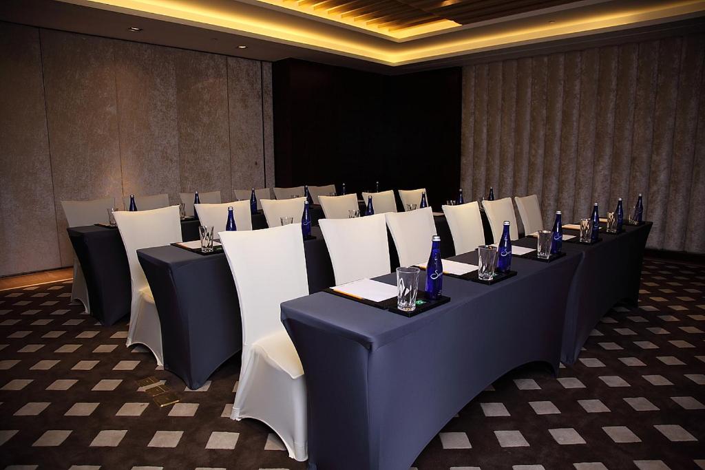 a set of tables and chairs in a room at Shanghai Hongqiao Airport Hotel - Air China in Shanghai