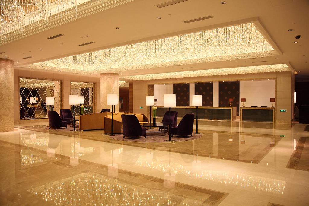 a lobby with chairs and a table in a building at Shanghai Hongqiao Airport Hotel - Air China in Shanghai