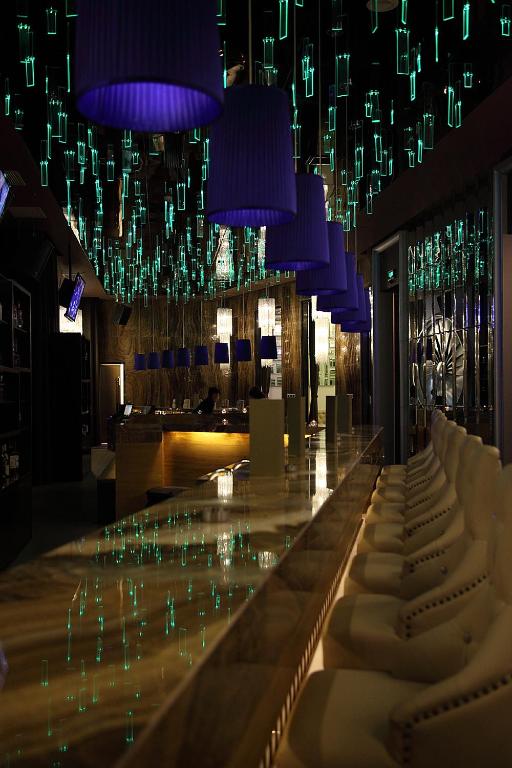 a bar in a restaurant with purple chandeliers at Shanghai Hongqiao Airport Hotel - Air China in Shanghai